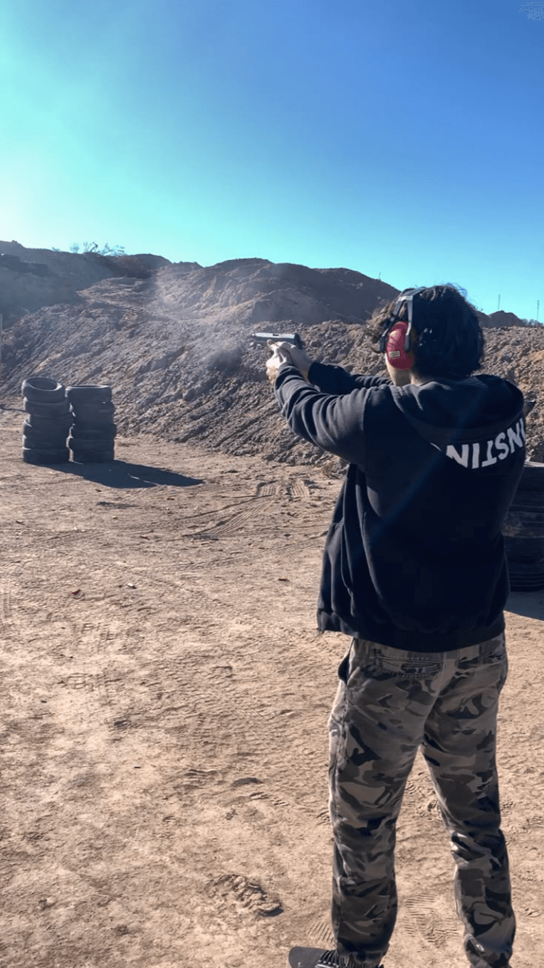 Tirador practicando con pistola en la línea de tiro